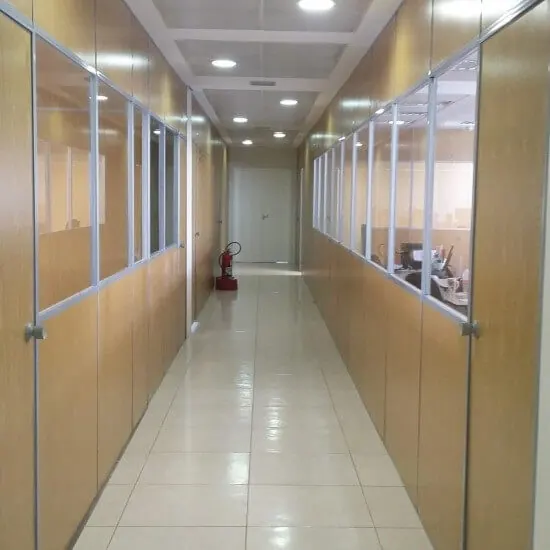Corredor com divisórias Eucatex e visores de vidro